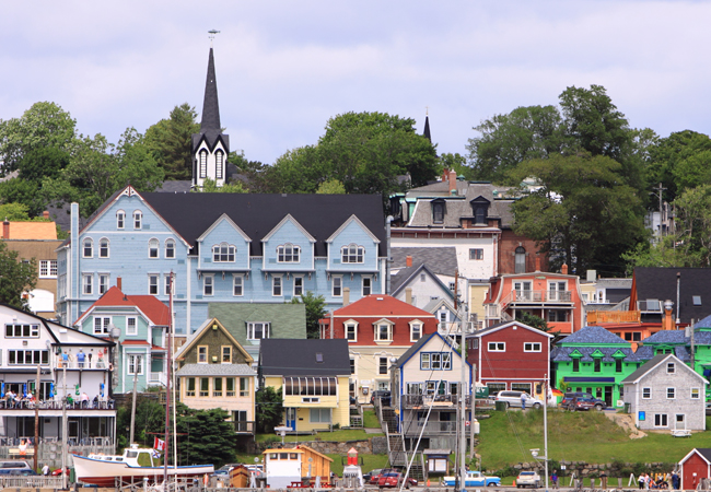 Colourful historic buildings in Nova Scotia with view of sail boat masts