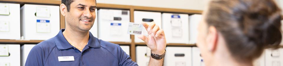 NSLC team member looking at a customers ID in the cannabis section of the store