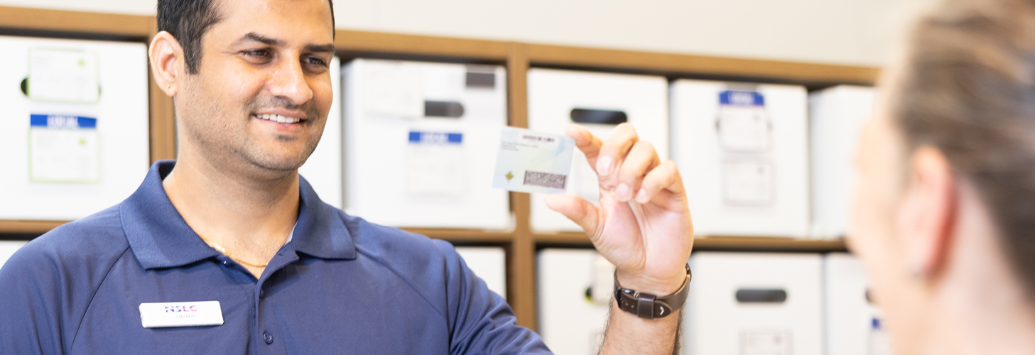 NSLC team member looking at a customers ID in the cannabis section of the store