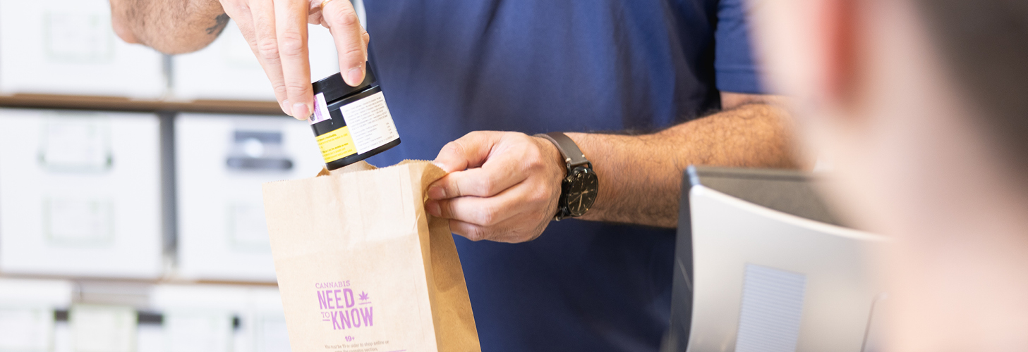 NSLC team member putting Cannabis product into a paper bag