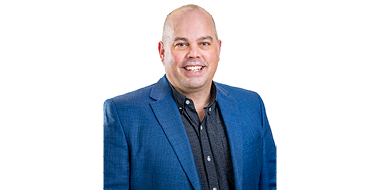 Greg Hughes stands in front of a white background