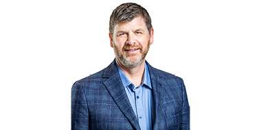 Paul Rapp stands in front of a white background