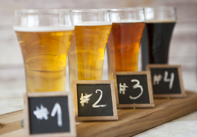 Four different kinds of beers in a row ranging from amber to dark with labels 1 through 4