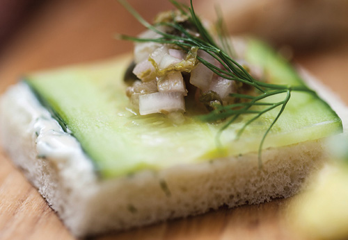 A slice of bread topped with dill mayo, cucumber and caper salsa 