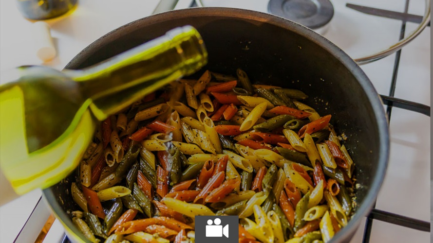 Wine being poured into a pot with penne.