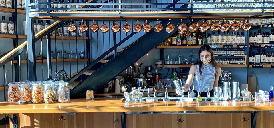 Large bar with a bartender making a cocktail in a shaker 