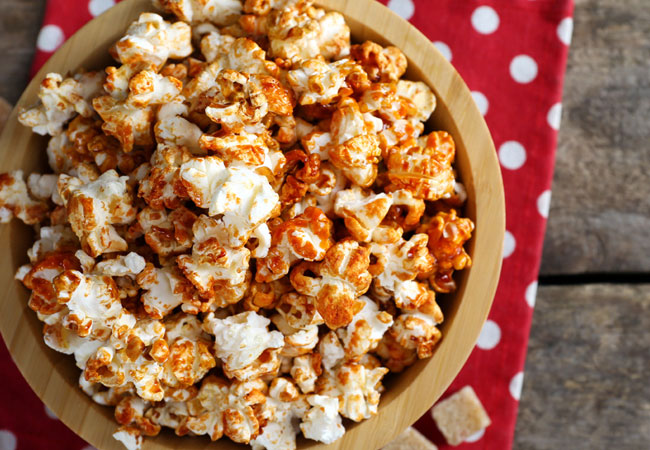 Ketchup seasoned popcorn in a red and white bowl