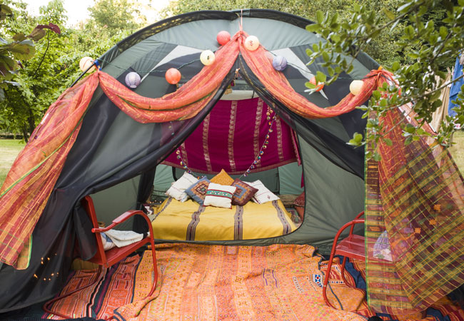 Tent with home amenities inside - chairs, a rug, mattress