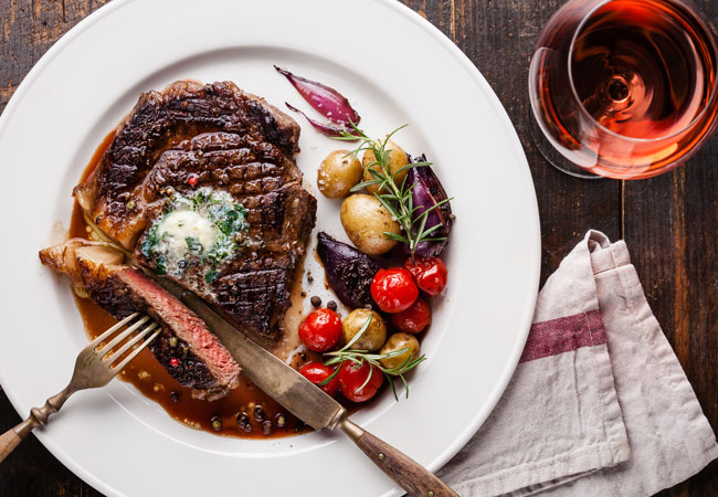 Flatlay image of steak and potatoes paired with a rose wine