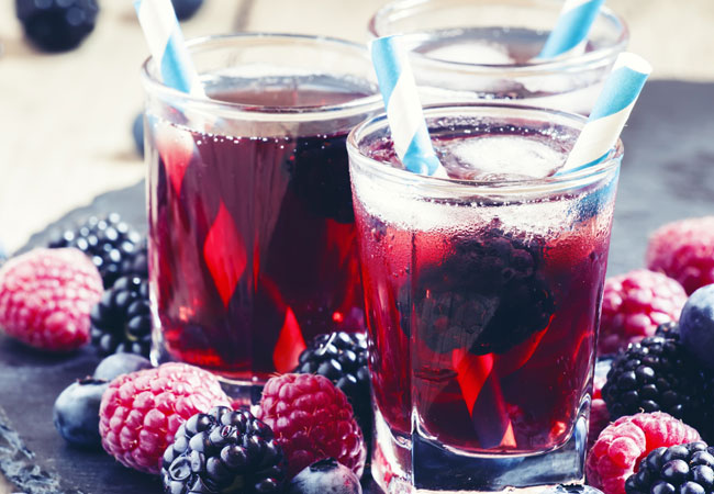 Three berry cocktails with blue and white straws