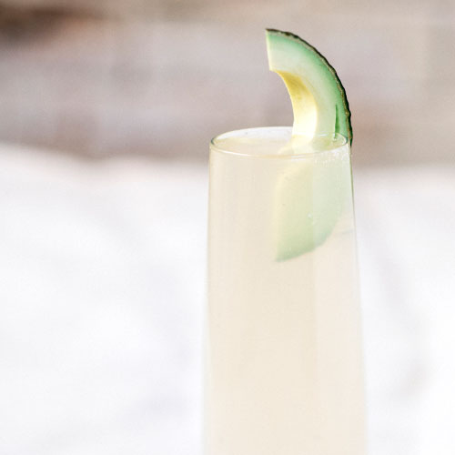 Avocado spritz in a glass garnished with a slice of avocado