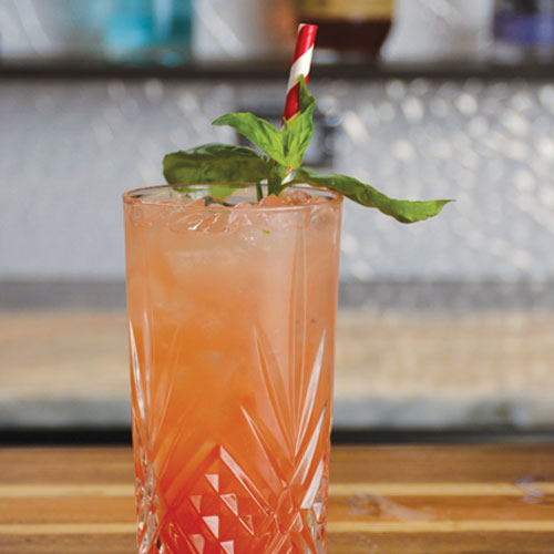 Close up of summer blush drink in a glass with a straw garnished with mint