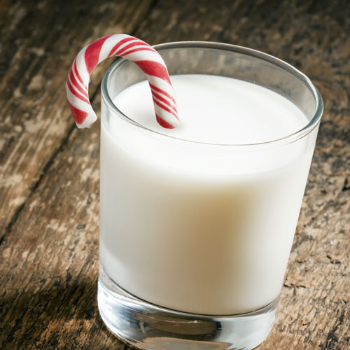 A white cocktail with a candy cane 
