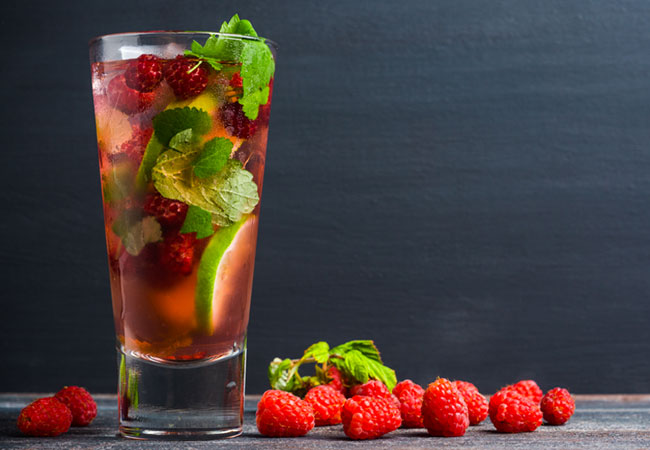 A red cocktail loaded with fresh fruit