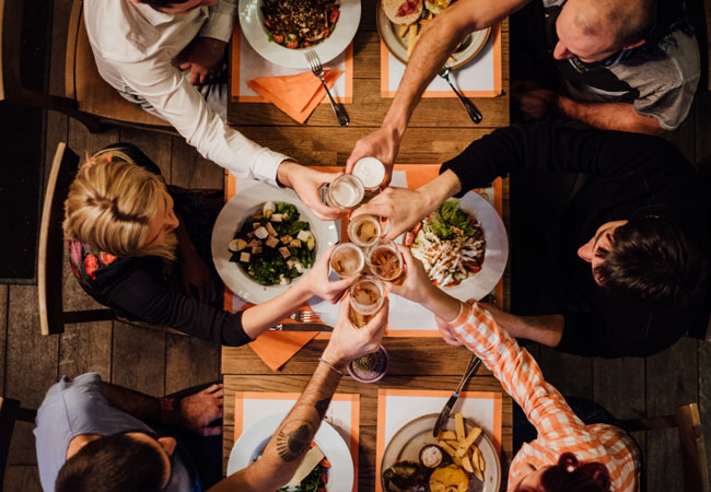 Overhead shot of a group of friends toasting over dinner