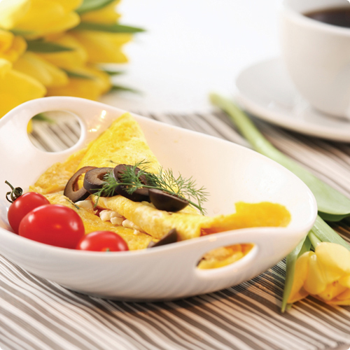 An omlette topped with mushrooms and cherry tomatoes and a mug of coffee