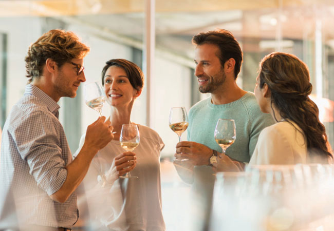 Two men and two women drinking white wine
