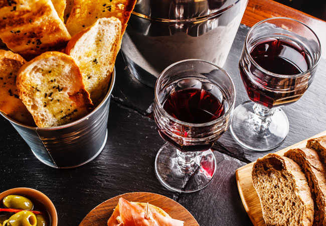 Glasses of red wine with assorted tapas on a table