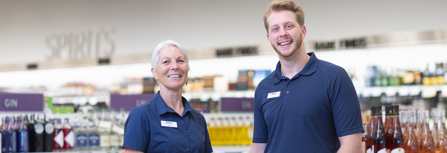 Two NSLC team members standing smiling in an NSLC store.