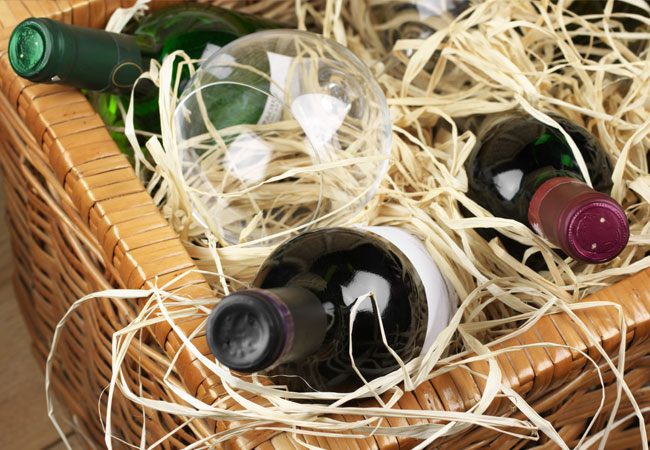 Wicker basket with wine bottles and straw