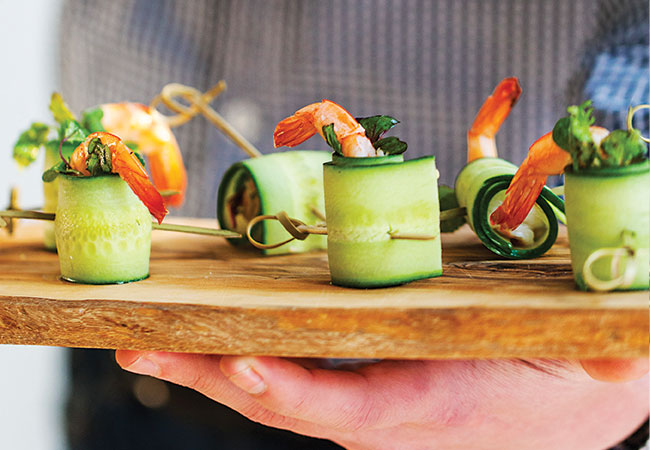 Cucumber and shrimp rolls on wooden board