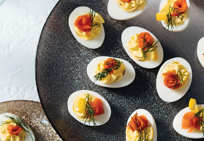 Halved eggs filled garnished with a green herb