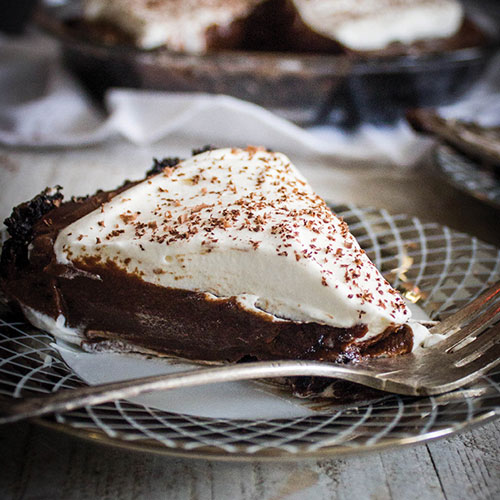 A piece of chocolate pie topped with whipped cream