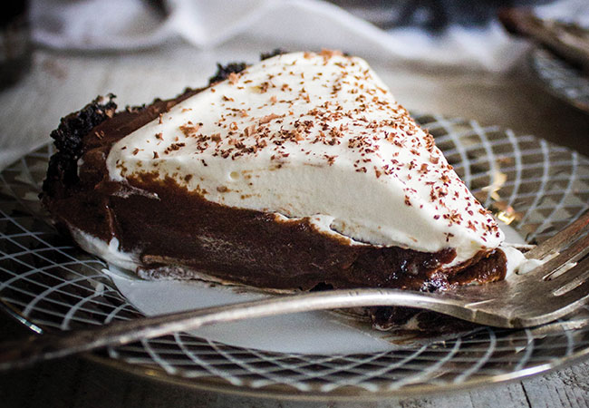 A piece of chocolate pie topped with whipped cream