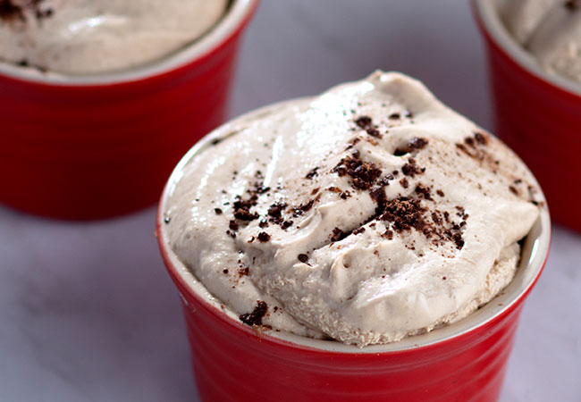 A red mug filled with whipped cream