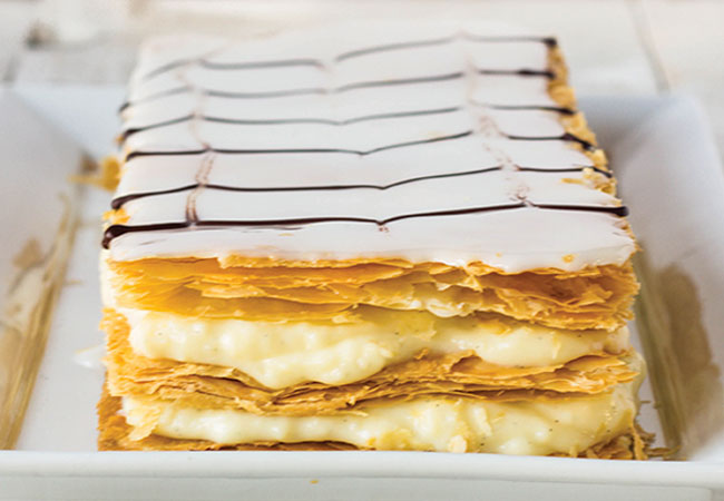 A piece of puffed pastry topped with pastry cream