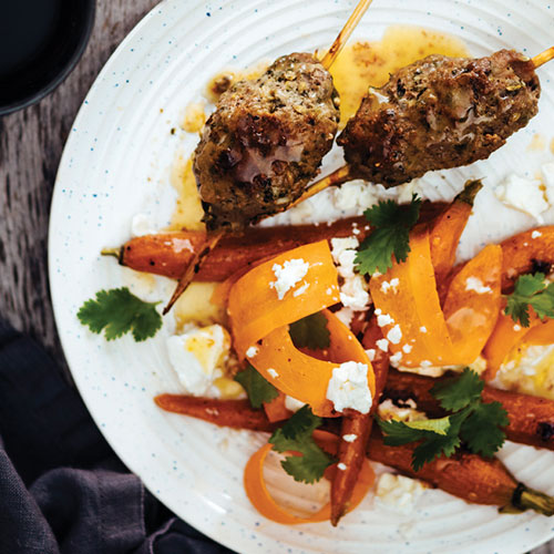 Skewered lamb with carrots and peppers, topped with feta