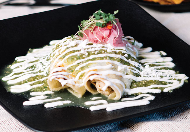 2 enchiladas drizzled with sour cream