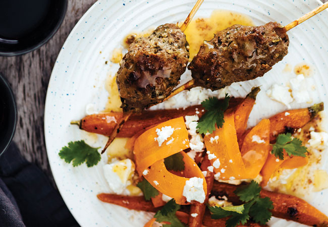 Skewered lamb with carrots and peppers, topped with feta
