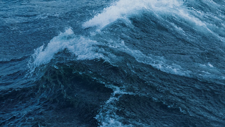 A crashing wave in the middle of the ocean.