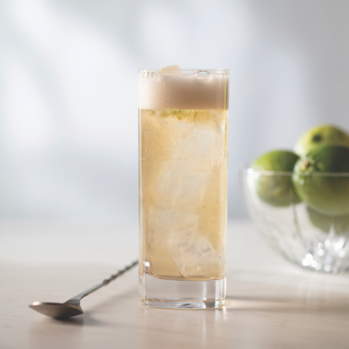 A glass filed with a caramel coloured liquid with foam. 