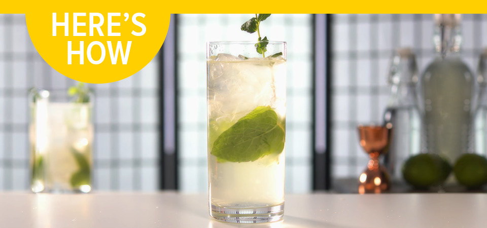 A tall glass filled with a clear cocktail garnished with mint and the headline "Here's How".