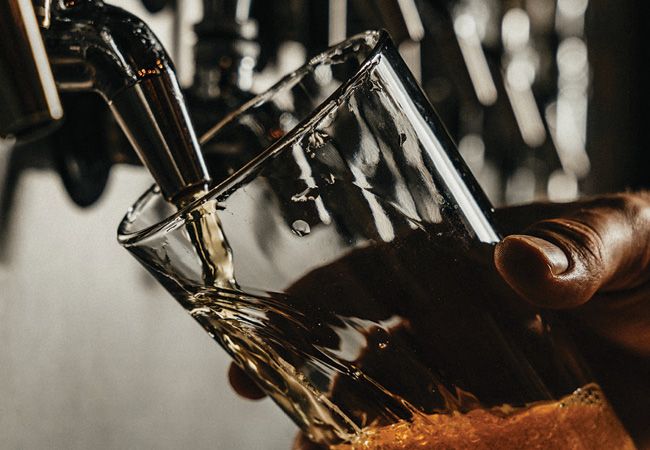 Pouring a glass of beer being from a tap. 