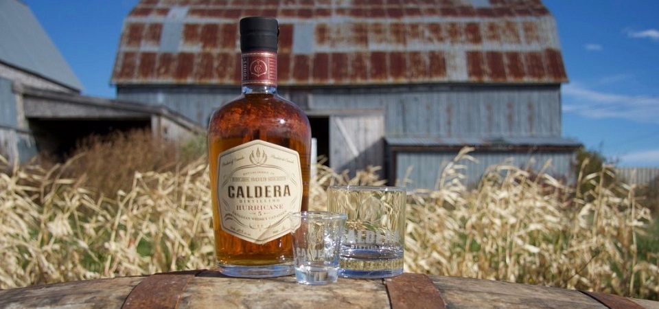 Bottle of Caldera 5 year Hurricane Whisky in front of a barn