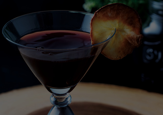 Martini Glass filled with Mulled Wine and Apple Martini with a dried apple slice as a garnish. 