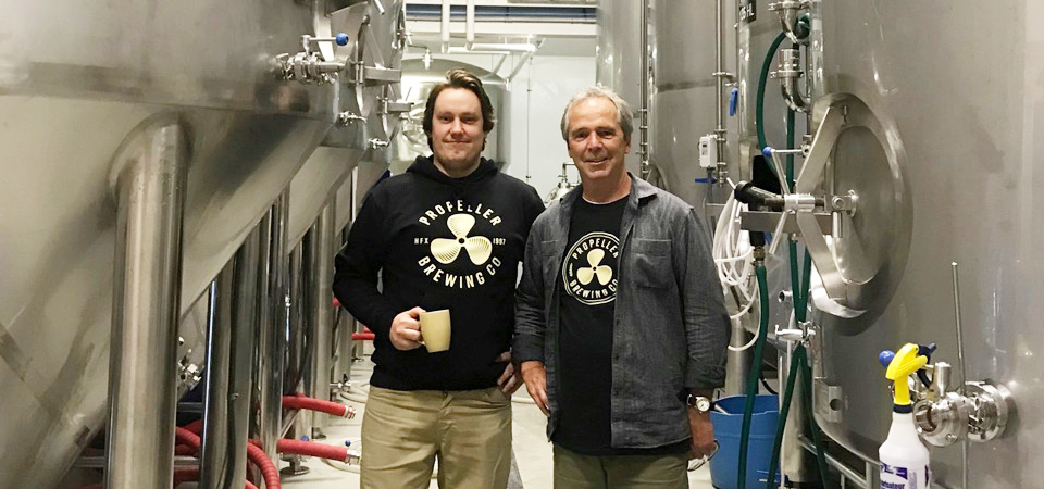 Mike and John Allen stand side by side in the brewing area of the Propeller facility. 