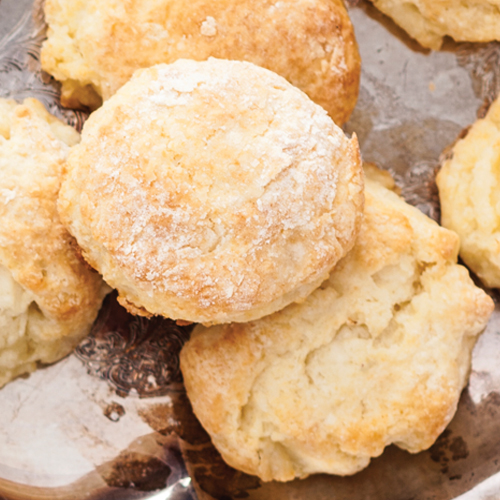 An arrangment of fluffy golden tea biscuits on a plate