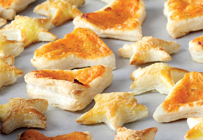 Assorted shapes of baked puff pastry on a cookie sheet