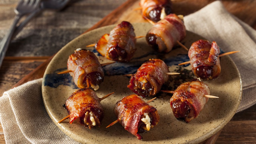 An assortment of bacon wrapped dates held together by toothpicks 