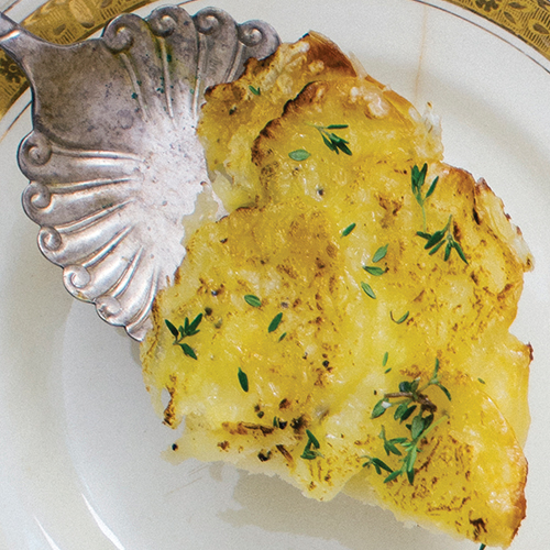 Fancy silver spooon with a serving of baked Patate Dauphinoise